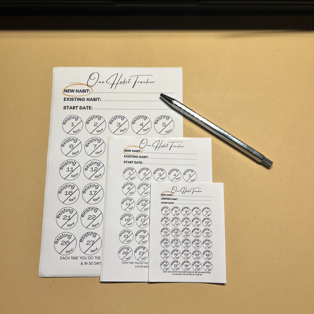 Habit tracker sheets with a pen on a beige background